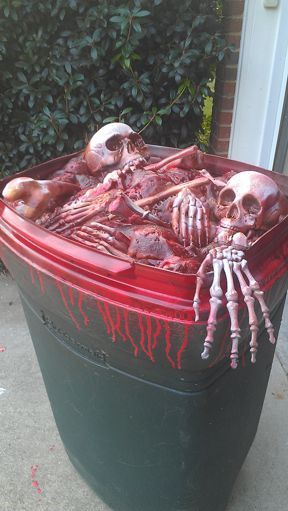 Make a trash can look like it is filled with bones and blood. Use a trash can, skeleton bone parts, Great Stuff Foam, and spray paint in red and mahogany lacquer.