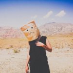 photo of woman with bag on her head with sad face drawing