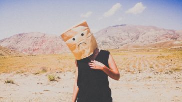 photo of woman with bag on her head with sad face drawing