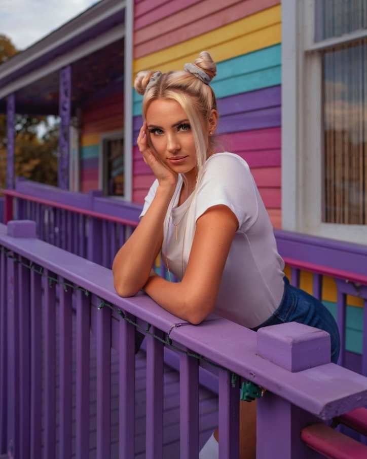 pensive blonde girl leaning on a fence