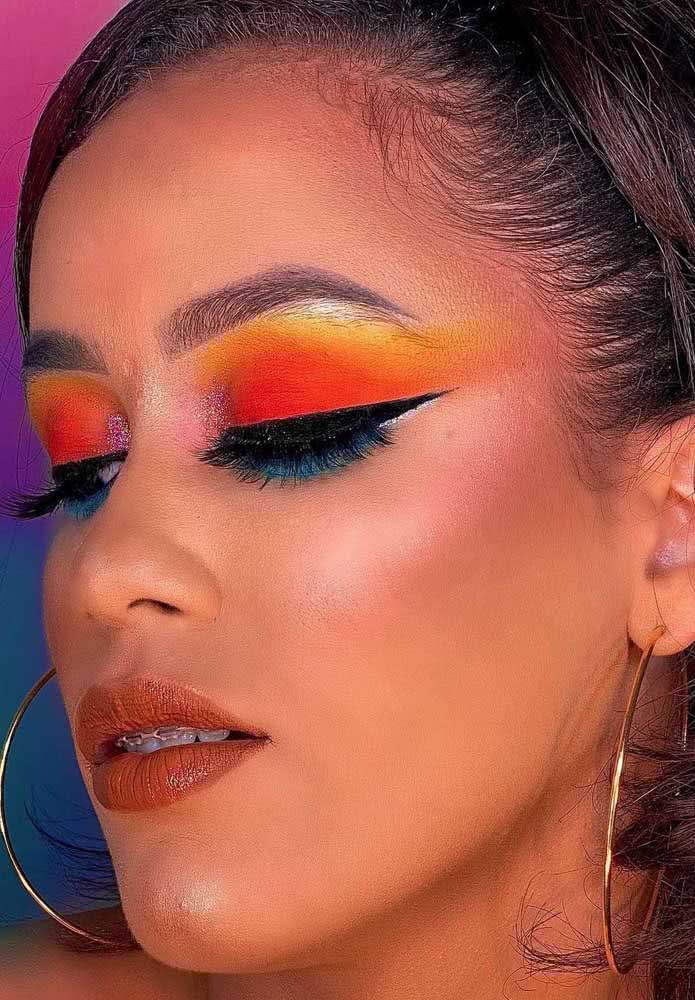 Orange and blue play a game between hot and cold in this striking eyeshadow for June party makeup
