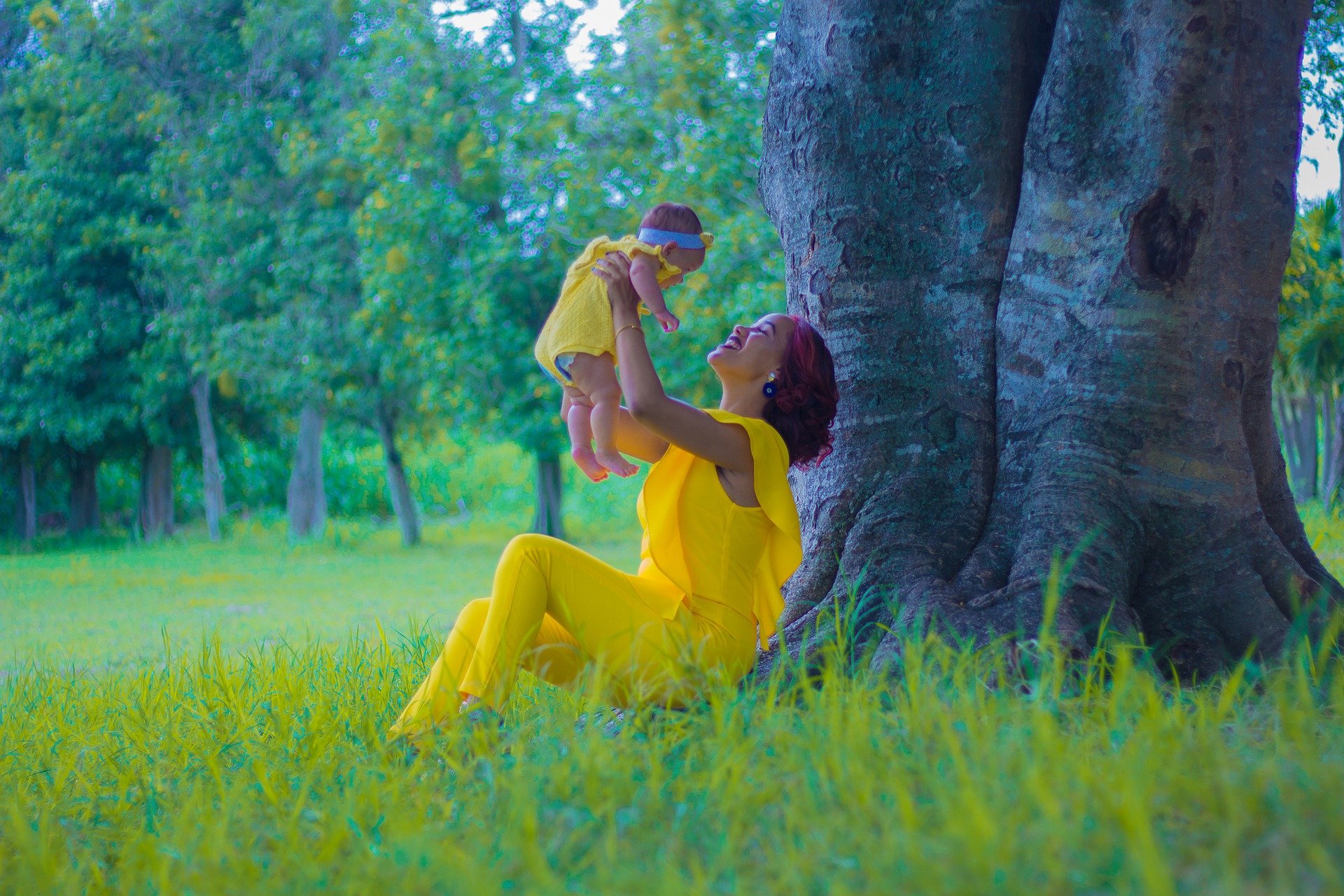 Woman holding baby outdoors.