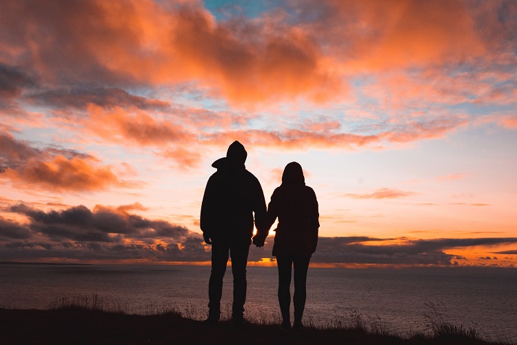 couple holding hands in the sunset
