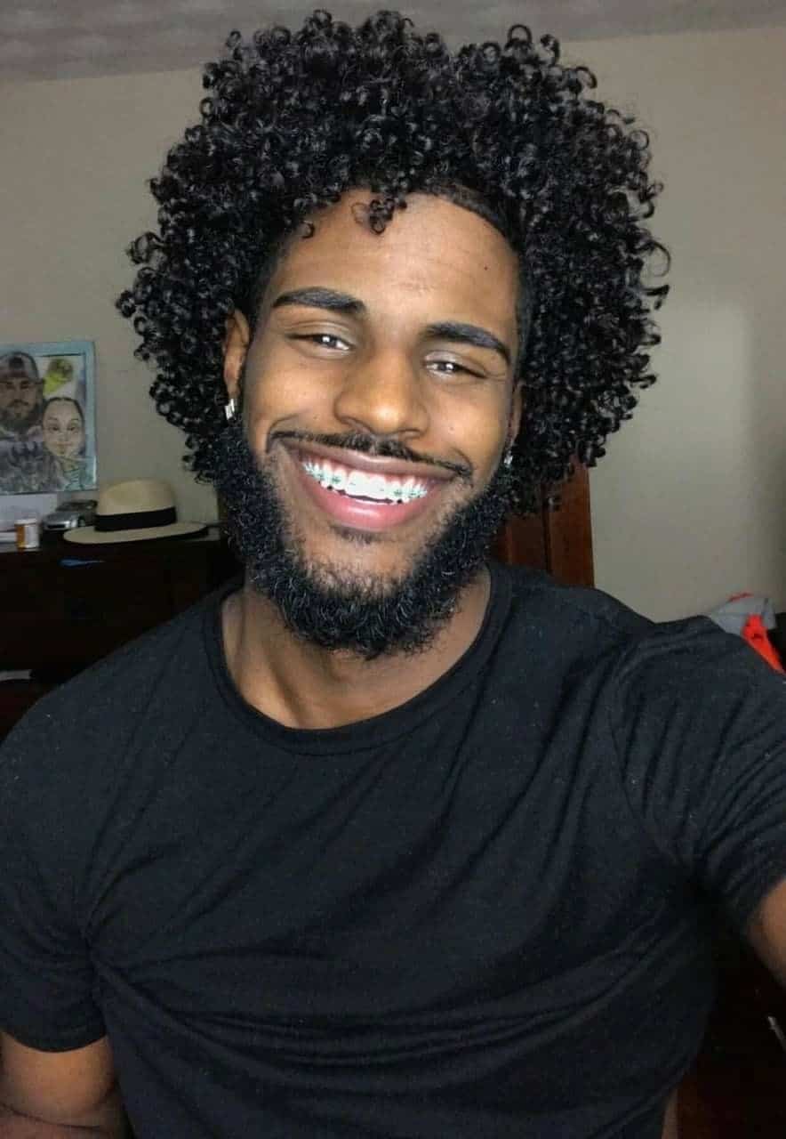 black man with black power haircut smiling