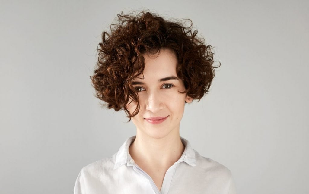 woman in white shirt and short wavy hair