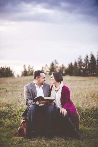 couple reading the bible in the field