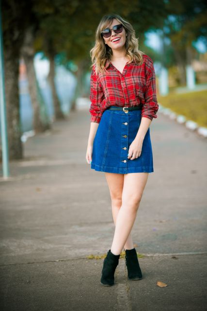 Model wears denim skirt and button with red shirt and black boot.