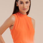 Women's Clothes for Work: Model wearing a basic crepe blouse with orange pleats.